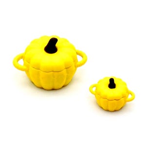 Può includere: Due pentole in ceramica gialle a forma di zucca con manici e coperchi neri. La pentola più grande è in primo piano e la pentola più piccola è sullo sfondo.