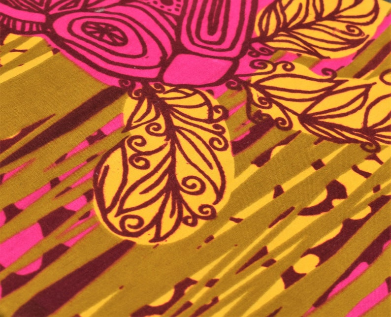 May include: Close-up of a fabric with a vibrant, abstract design. The pattern features large, stylized floral elements in hot pink and yellow, outlined in dark brown. The background has diagonal stripes in olive green and maroon.