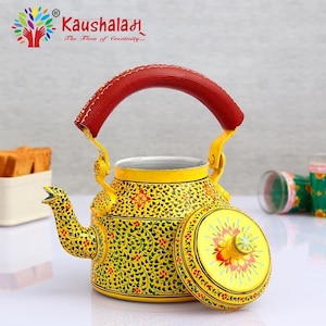 May include: A yellow metal teapot with a red handle and a floral design. The lid is open and the inside of the teapot is visible. The teapot is decorated with intricate floral patterns in yellow, green, and red.