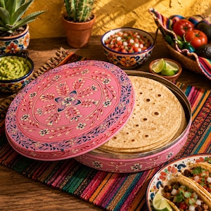 Peut inclure: Une boîte ronde en métal rose pour tortillas avec un motif floral sur le couvercle, contenant une pile de pains plats ronds. Le récipient présente des motifs complexes de feuilles bleues et blanches et de petites fleurs assorties au bol.