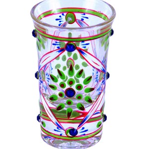 May include: A clear glass tumbler featuring hand-painted floral patterns in vibrant green, blue, and red. The design includes symmetrical petal motifs, thin horizontal bands around the rim and base, and small blue glass studs applied to the exterior.
