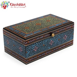 May include: A black wooden box with a floral design painted in blue, green, pink, and orange. The box has a brass knob on the lid and the words "Kaushalah The Flow of Creativity..." are printed on the top.