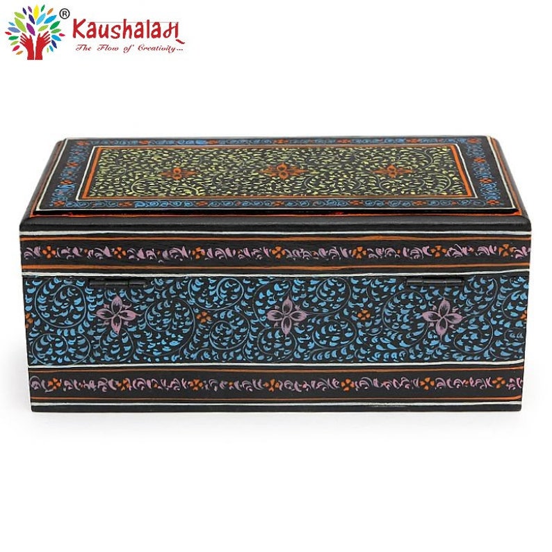 May include: A black wooden box with a hinged lid. The box is decorated with intricate floral patterns in shades of blue, yellow, orange, and pink. The lid is closed.