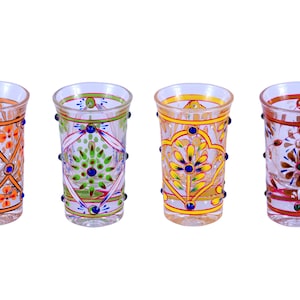 May include: A set of six clear glass shot glasses, each featuring distinct hand-painted floral and geometric patterns in vibrant colors including purple, orange, green, yellow, brown, and red, accented with small raised dots along the sides.
