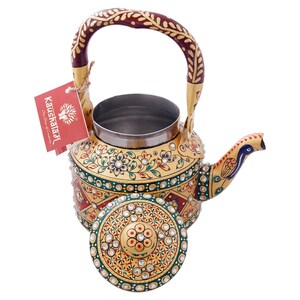 May include: A gold metal teapot with a peacock design on the spout. The teapot is decorated with colorful floral patterns and rhinestones. The lid is also decorated with rhinestones and floral patterns. The teapot has a red and gold handle.