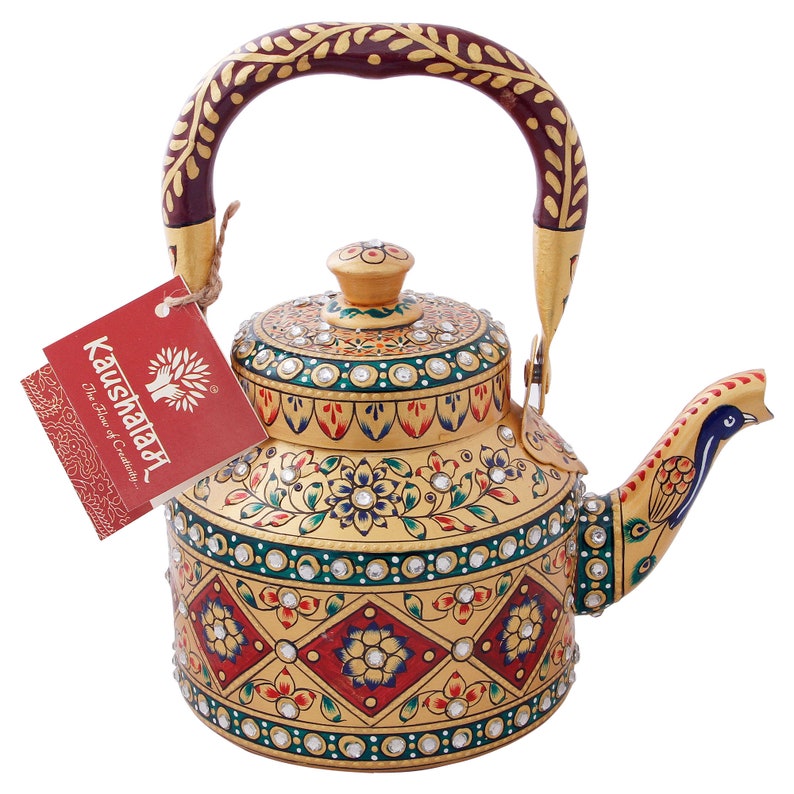 May include: A gold metal teapot with a peacock-shaped spout and a red and gold painted handle. The teapot is decorated with intricate floral designs and rhinestones.