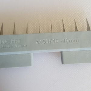 May include: Gray plastic tool with a row of 10 metal spikes. The tool is labeled "MATFER Made in France" and "4459510 - 10mm".