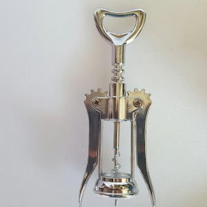 May include: A silver metal corkscrew with a lever and a worm for opening wine bottles.