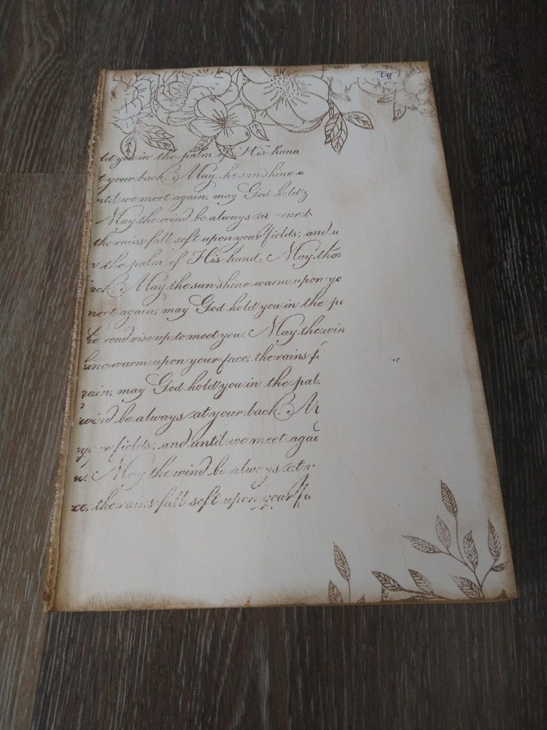 May include: A handwritten note with a floral design on the top and bottom. The note reads: "litysk in the palm of His hand your bank May he sunshine until we meet agains my God hold you May the mind be always in ward the miss fell soft upon your fields, and a vale palen of His hand. Mayither ack May the sunshine warm spon ye nere agam may God hold you in the ju be wadrisonpetermeet you. May therein incwarm spon your face, therains f zair, may God hold you in the pal wid he always at your back Mr y, fiches and antil we meet agai May the wind be atwe ys cate xe the rains fall soft spongeakhe"