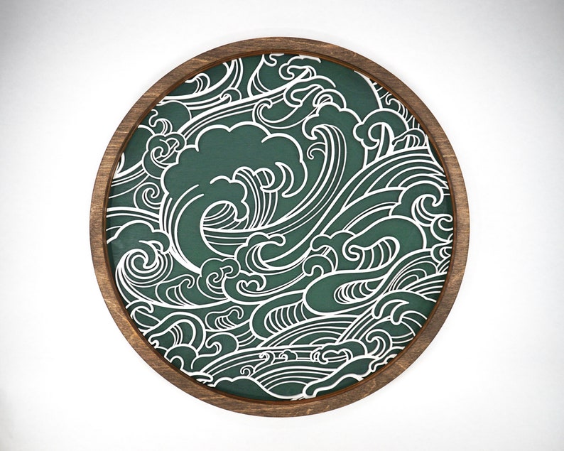 May include: A round wooden wall decoration with a green background and a white wave pattern.