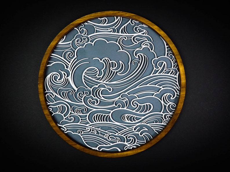 May include: A circular wooden frame featuring a blue and white wave pattern. The waves are stylised and intricate, creating a dynamic and flowing design.