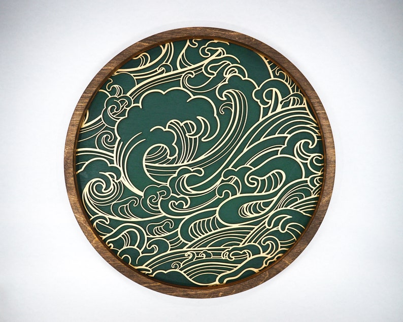 May include: A round wooden tray with a green background and a gold wave pattern. The tray is ideal for serving snacks or drinks.