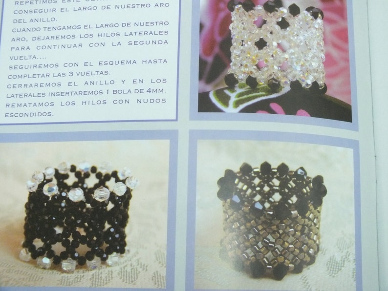 May include: Close-up of a page with instructions and images of beaded rings. The rings are made with clear and black beads, showcasing intricate patterns. The text in Spanish provides guidance on the ring-making process.