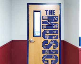 May include: A light wood door with a blue frame and a rectangular window. The door features large blue vertical text that reads THE MUSIC ROOM, with various musical instrument icons integrated into the letters, including a drum set and guitar.