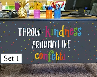 May include: A dark gray rectangular desk front panel featuring a colorful confetti pattern and the text "THROW kindness AROUND LIKE confetti" in various bright colors. The text "Set 1" appears in a white box on the lower left side of the panel.