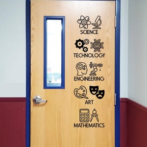 May include: A light wood door with a blue frame and a vertical rectangular window. Black vinyl decals are applied to the door, featuring icons and labels for Science, Technology, Engineering, Art, and Mathematics, arranged in a vertical column.