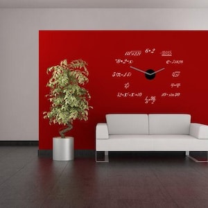 May include: A wall clock featuring a black center hub with two silver hands, mounted directly onto a red wall. Instead of traditional numbers, the clock face displays twelve distinct mathematical equations in white text arranged in a circle.