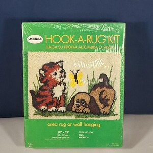 May include: A Malina Hook-A-Rug Kit featuring a colorful design of a cat, dog, and butterfly. The kit includes materials to create a 20" x 27" (51 x 69 cm) area rug or wall hanging. The package is green and sealed in plastic.