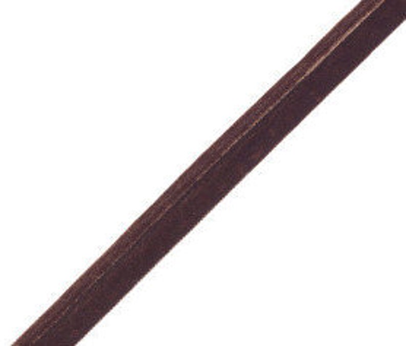 May include: A single strip of dark brown velvet ribbon positioned diagonally across the frame. The ribbon features a soft, textured pile surface with a consistent deep brown colour and finished edges running along both sides of the length.