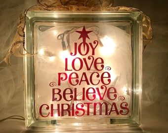 Gioia, amore, pace, credere, blocco di vetro illuminato di Natale
