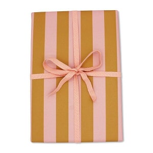 Könnte beinhalten: Rosa-gold gestreiftes Geschenkpapier mit einer rosa Schleife, die zu einer Schleife gebunden ist.