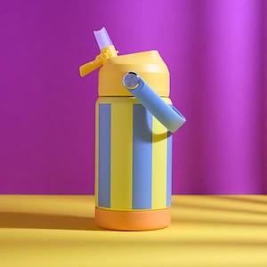 Puede incluir: Una botella de agua colorida con tapa amarilla y asa azul. El cuerpo de la botella es amarillo con rayas azules verticales. La base es naranja y la pajita es transparente. Diseñada para bebidas frías.