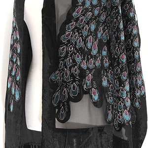 May include: Black shawl with a sheer overlay, featuring a velvet trim and fringe. The shawl is adorned with a peacock feather design in teal, purple, and silver. A stylish accessory for special occasions.