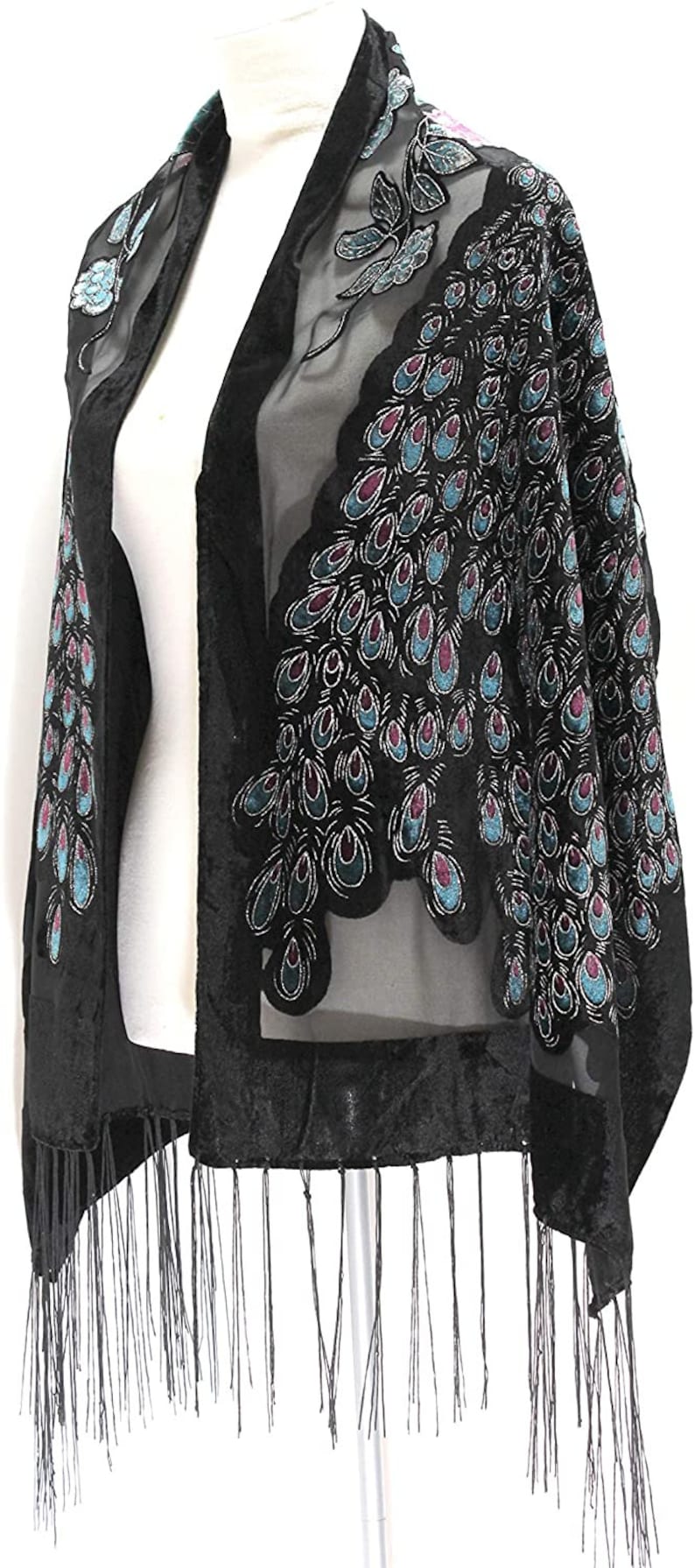 May include: Black shawl with a sheer overlay, featuring a velvet trim and fringe. The shawl is adorned with a peacock feather design in teal, purple, and silver. A stylish accessory for special occasions.