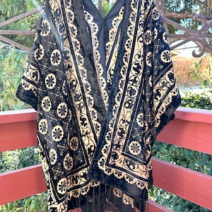 May include: Black velvet kimono with gold floral embroidery and fringe trim.