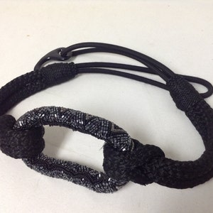 May include: A black beaded rope belt with a decorative beaded oval buckle.