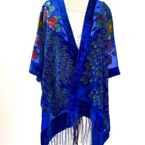 May include: A blue velvet and silk shawl with a peacock design and fringe. The shawl is on a white background.