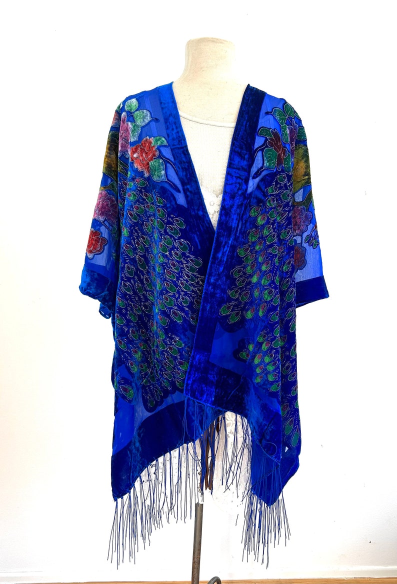 May include: A blue velvet and silk shawl with a peacock design and fringe. The shawl is on a white background.