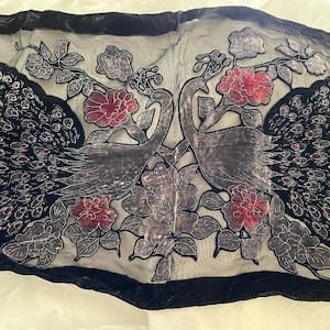 May include: A black and gray textile with a velvet border, featuring two stylized peacocks facing each other. The design includes red and gray floral accents and peacock feather details.