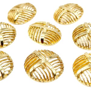 Könnte beinhalten: Acht goldfarbene runde Dekor-Verzierungen aus Metall mit einem Kreuzmuster. Die Verzierungen haben einen Durchmesser von etwa 2,5 cm.