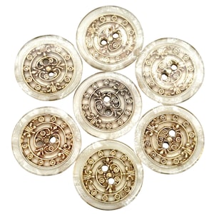 May include: Seven white buttons with gold accents and a decorative design. The buttons have two holes each.