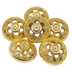 May include: Five gold-toned buttons with a decorative floral design. The buttons have a raised centre with a smaller floral design and a scalloped edge.