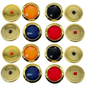 May include: Twelve round, gold-rimmed buttons with different coloured centres. The colours are orange, black, red, and blue.