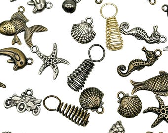 May include: Assortment of gold, silver, and bronze metal charms with various sea life and other designs. The charms include a starfish, seashells, seahorses, fish, and dolphins. There are also a few spring-shaped charms.