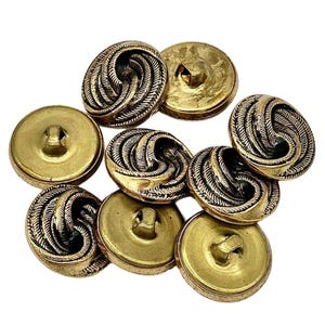 May include: Eight gold-toned buttons with a decorative, woven design. The buttons have a flat back and a shank for sewing.