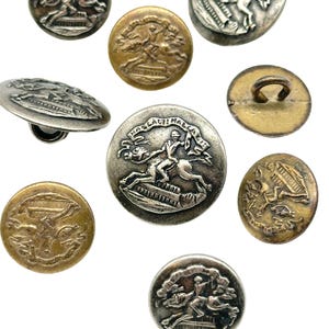 May include: A collection of ten antique silver and gold buttons featuring a raised image of a man on horseback with a banner that reads "HOS LAUTI MALACA".