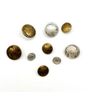 May include: A collection of eight vintage-style buttons featuring a profile of a Native American. The buttons are made of metal and have a silver and gold finish.