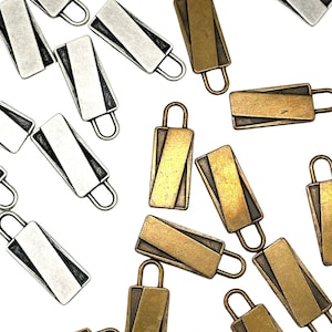 May include: A collection of silver and gold-toned metal zipper pulls with a diagonal line design. The zipper pulls are rectangular in shape and have a loop at the top.