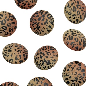 May include: Nine round, flat buttons with a leopard print pattern in shades of brown, black, and orange.