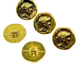 May include: Four gold-toned buttons with a raised design of a person's head wearing a helmet. The buttons have a smooth back.