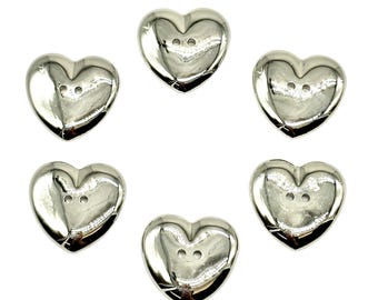 May include: Six silver heart-shaped buttons with two holes each.