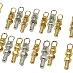 May include: A collection of 18 gold and silver metal charms shaped like nuts and bolts with a loop at the top.