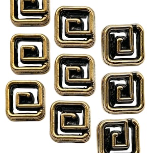 May include: Nine square metal beads with a gold-tone finish and a black spiral design. The beads are arranged on a white background. The beads have a vintage or antique appearance.