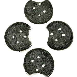 May include: Four chocolate sandwich cookies with a white cream filling. Each cookie has a bite taken out of it.