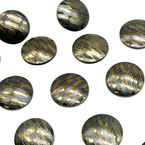 May include: Ten round, gold and silver patterned buttons. The buttons have a geometric design with a raised texture.