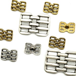 May include: Assortment of metal buttons in gold and silver with a woven design. The buttons are square shaped with rounded corners.